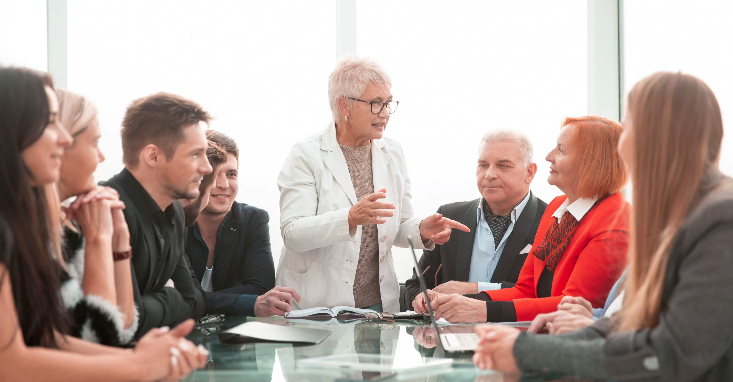 family retreat, family meeting, multi-generations sitting at conference table, professional, woman leading discussion, collaborating, family business, enterprise, gathering