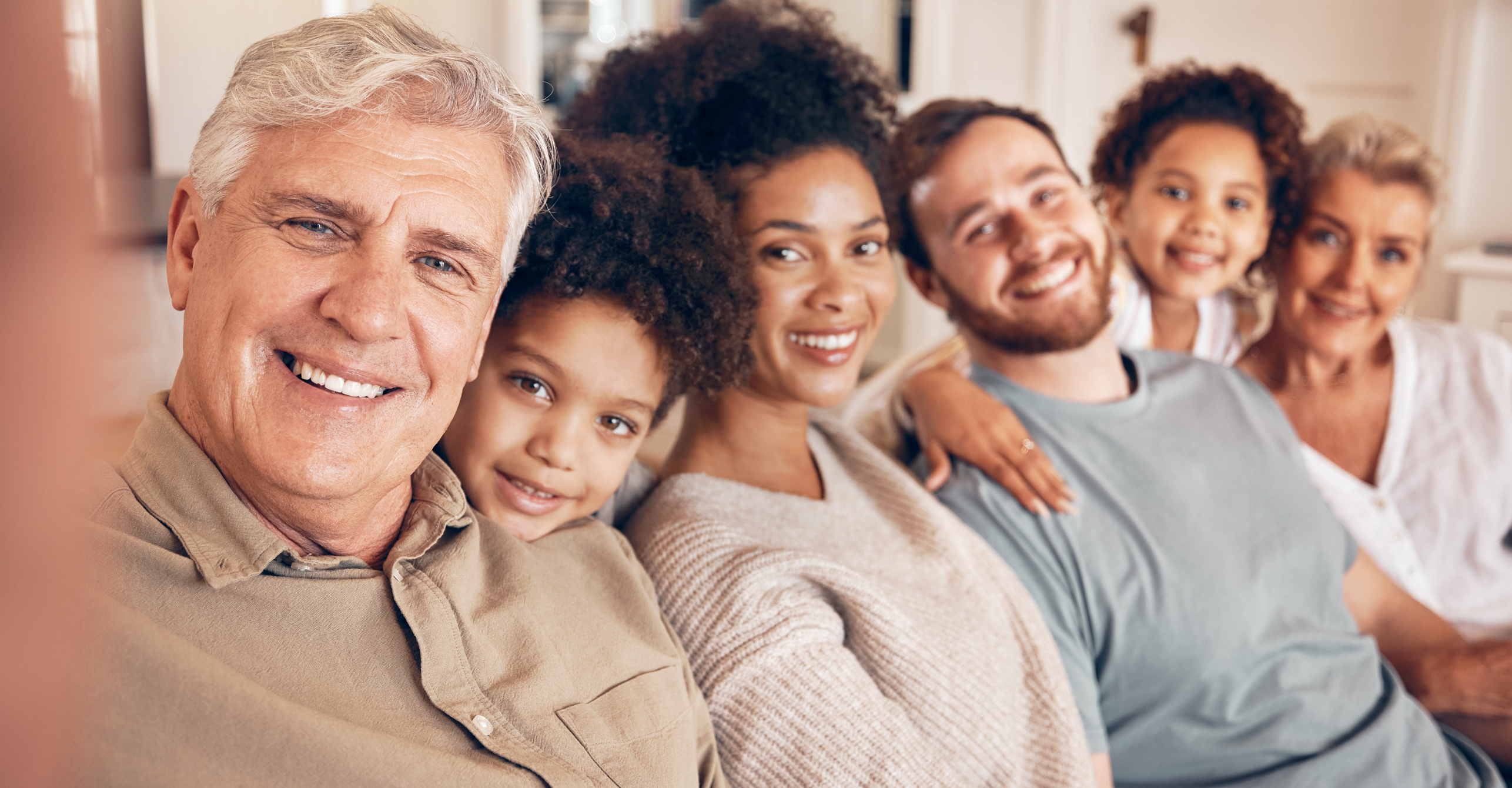 Impact of Wealth, multi-generational, multi-cultural family, sitting on sofa, happy, content, loving, heartfelt conversation