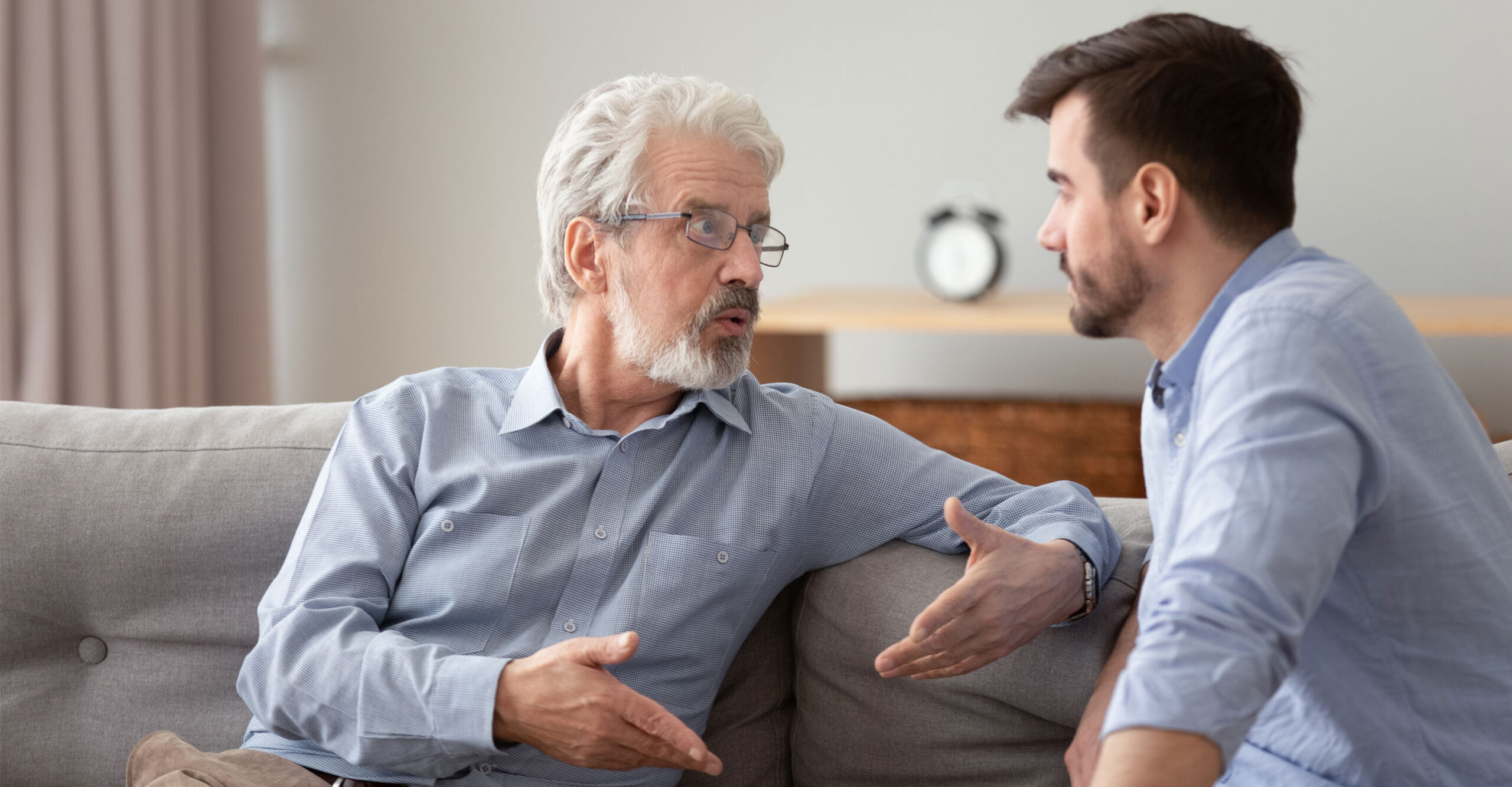 Legacy, father and son, having meaningful discussion, sitting on sofa, inheritance, estate planning, intention, honoring legacy