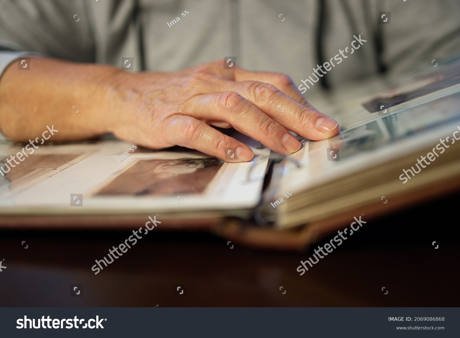 stock-photo-old-woman-looking-at-family-photo-album-2069086868